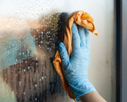 Fensterreinigung und Glasreinigung Hand reinigt nasses Glas.