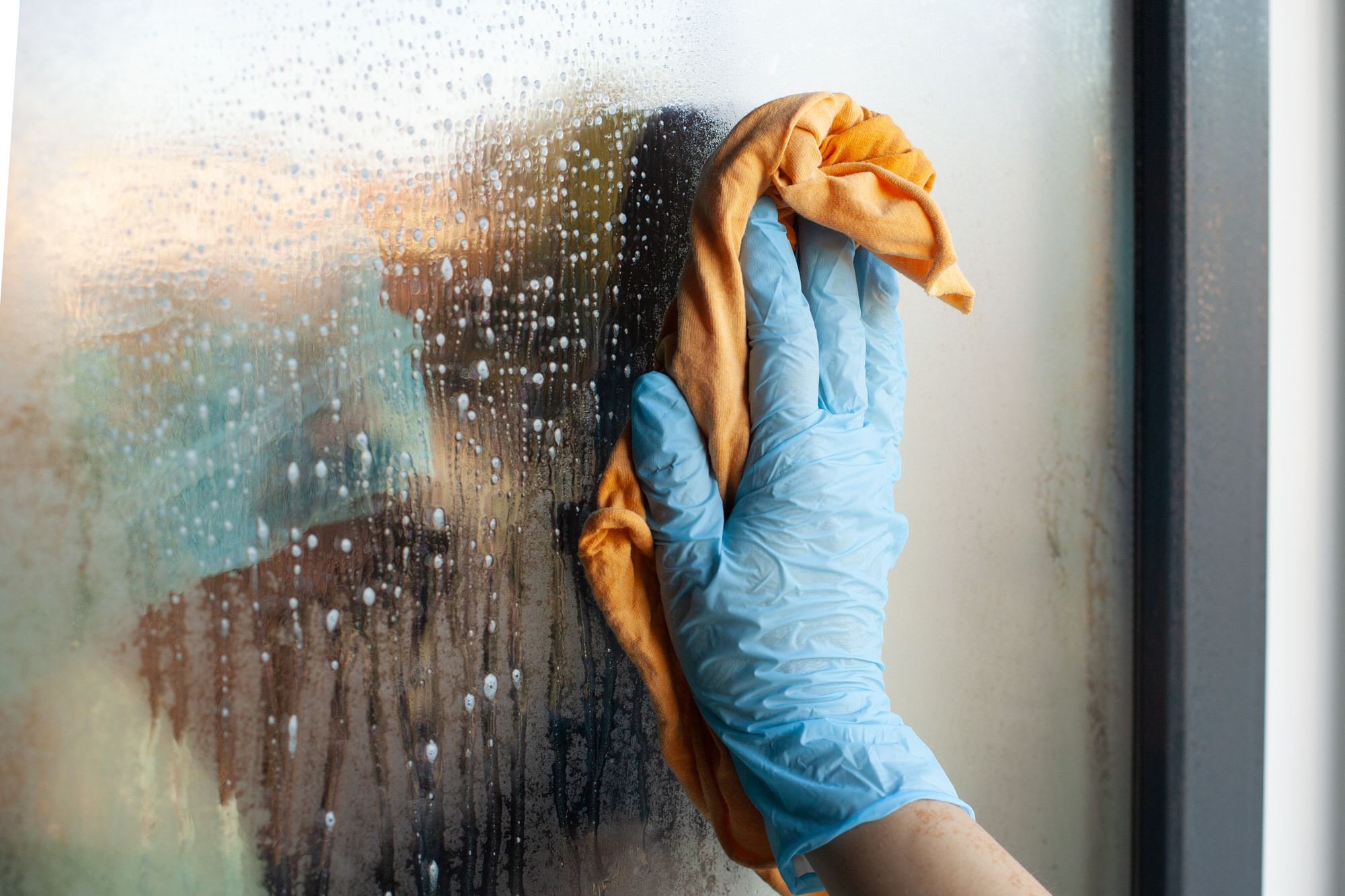 Fensterreinigung und Glasreinigung Hand reinigt nasses Glas.